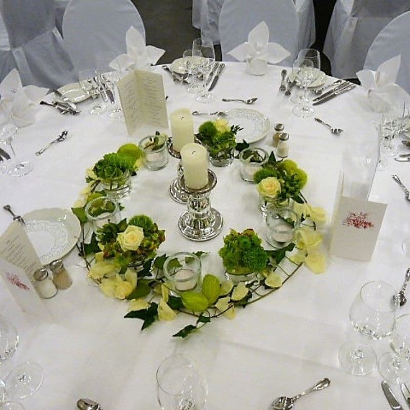 Zylindergläser mit Blumendeko und Teelichtern als Kranz gestellt Burghotel Noerten-Hardenberg